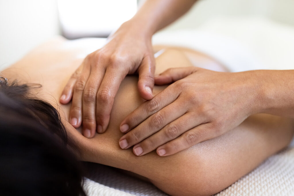 Massage therapy on the upper back of a patient