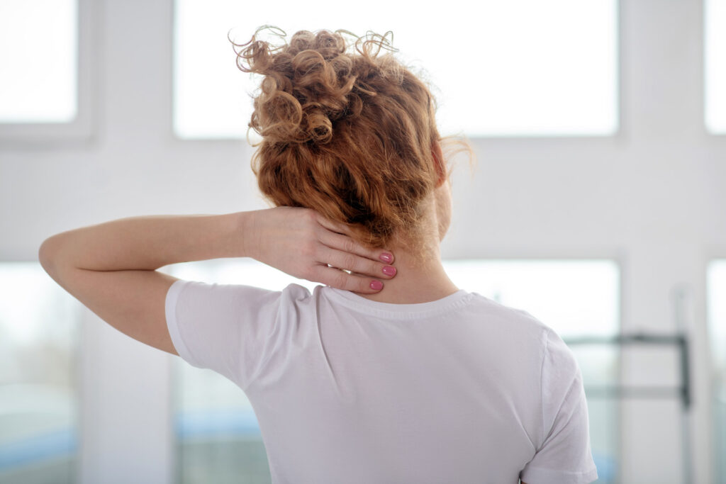 Woman holding her neck due to neck pain before seeking treatment at iGood Health Centre in Richmond Hill